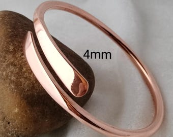 May include: A rose gold-coloured bypass bangle bracelet with a smooth, polished finish. The metal band features a rounded profile and a width of 4mm as indicated by the text printed on the image. The bracelet has an open design with overlapping ends.