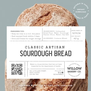 May include: A loaf of classic artisan sourdough bread with a white label. The label includes freshness tips, ingredients, and the text "Classic Artisan Sourdough Bread." The bread is baked fresh on 12/03/26 and weighs approximately 1190 grams.