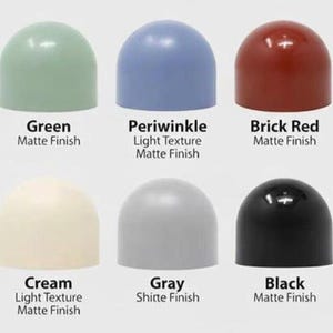 May include: Ten dome-shaped objects arranged in two rows, labelled with colours and finishes: Mauve satin, Green matte, Periwinkle light texture matte, Brick Red matte, Yellow satin, Coal Blue matte, Cream light texture matte, Gray matte, Black matte, and White light texture matte.