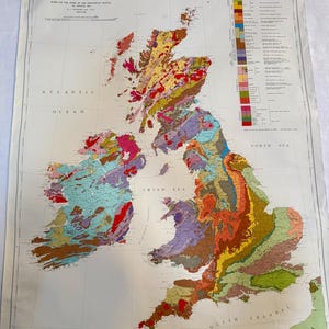 Könnte beinhalten: Eine große, detaillierte geologische Karte der Britischen Inseln mit einer mehrfarbigen Darstellung von Gesteinsformationen in Großbritannien und Irland. Die Karte enthält eine Legende auf der rechten Seite, Gitternetzlinien und den Text Geological Map of the British Islands, basierend auf der Arbeit des Geological Survey.