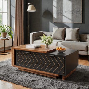 May include: A rectangular coffee table featuring a two-tone design with a natural wood top and a matte black base. The front panels display a gold chevron pattern and include two black horizontal handles. The table has a tiered, layered structure.
