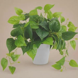 May include: A vibrant green artificial plant with heart-shaped leaves, overflowing from a white ceramic pot. The plant's leaves vary in shades of green, creating a natural and lively appearance. The pot is simple and modern, providing a clean contrast to the foliage.