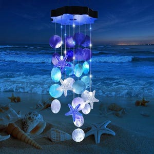 May include: A solar-powered wind chime featuring circular blue and white translucent discs and textured starfish ornaments. The structure hangs from a black circular base and emits a glowing light, creating a gradient of blue and white tones.