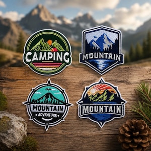 May include: Four embroidered patches featuring mountain landscapes. The top left is circular with green mountains and the text CAMPING. The top right is shield-shaped with blue mountains and the text MOUNTAIN. The bottom two are compass-shaped with the text MOUNTAIN.