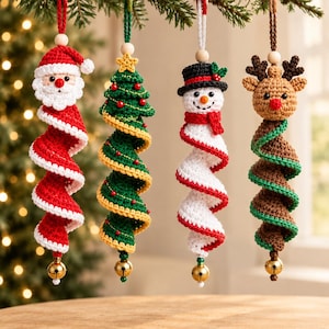 May include: Four hanging crochet ornaments featuring a Santa Claus, a green Christmas tree, a snowman, and a reindeer. Each figure has a spiral-shaped body, a wooden bead at the top, and a small gold-colored jingle bell at the bottom.