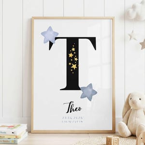 May include: A framed wall art print featuring a large black letter T decorated with small gold stars. The print includes the name Theo in black script, the date 23.04.2026, and the weight 3.56 kg and length 69 cm, accented by two light blue stars.