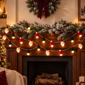 May include: A string of festive lights featuring miniature knitted hats in red, green, and white as bulb covers. Each hat is topped with a small pom-pom. The lights are arranged in a draped pattern, emitting a warm glow against a dark background.