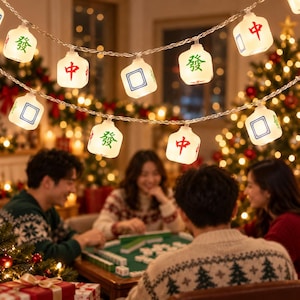 May include: A string of LED lights featuring white, cube-shaped covers designed to resemble Mahjong tiles. The tiles display red and green Chinese characters and blue square outlines. The lights are connected by a thin, clear wire.