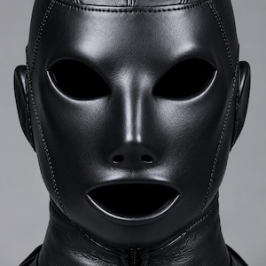May include: A black full-head mask constructed from smooth material with visible stitched seams. The mask features oval-shaped eye openings, small circular nostril holes, and a wide mouth opening. A vertical zipper runs down the front neck area.