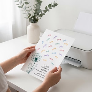 May include: A white rectangular paper print featuring a green dandelion illustration on the left side. The text reads: LEHRER s&auml;en Samen des WISSENS die ein Leben lang wachsen. DANKE FRAU RAU St. Anne Schule, Klasse 3, 2024. Colourful names are scattered around.