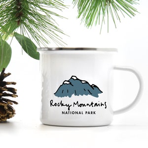 May include: White enamel camping mug with a black and blue illustration of mountains and the text "Rocky Mountains National Park".