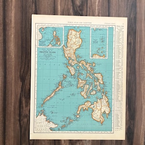 Può includere: Una mappa vintage delle Filippine, con un oceano turchese e masse terrestri beige. La mappa mostra dettagliate linee costiere ed è incorniciata con un bordo beige. Il titolo "Philippine Islands" è visibile.