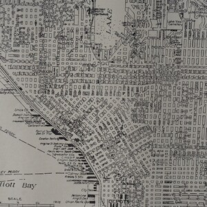 May include: A black and white map of a city with streets and buildings. The map includes the names of streets, parks, and bodies of water. The map is labeled "Elliott Bay" and includes a scale.