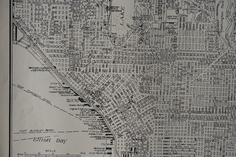 May include: A black and white map of a city with streets and buildings. The map includes the names of streets, parks, and bodies of water. The map is labeled "Elliott Bay" and includes a scale.