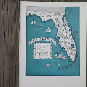 Puede incluir: Mapa vintage de Florida con ilustraciones en color turquesa y blanco. El mapa presenta veleros, palmeras y los nombres de ciudades como Jacksonville, Miami y Tampa. La palabra "Florida" se muestra en una pancarta.