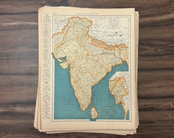 May include: A stack of vintage maps featuring a detailed map of India, with a teal blue ocean and tan landmass. The map is from the "World Atlas and Gazetteer". The map is printed on aged paper.