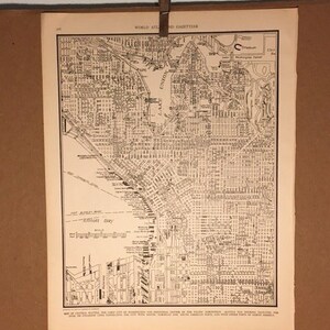 May include: A black and white map of Seattle, Washington. The map shows the city's streets, parks, and bodies of water. The map is titled "World Atlas and Gazetteer".