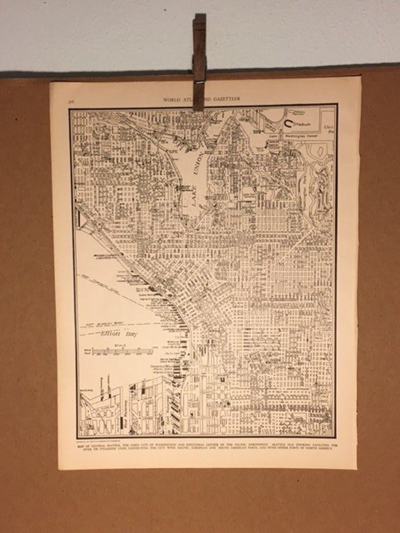 May include: A black and white map of Seattle, Washington. The map shows the city's streets, parks, and bodies of water. The map is titled "World Atlas and Gazetteer".