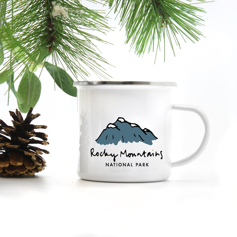 May include: White enamel camping mug with a black and blue illustration of mountains and the text "Rocky Mountains National Park".