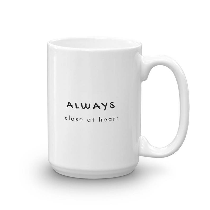 May include: White ceramic mug with black text that reads "ALWAYS close at heart".