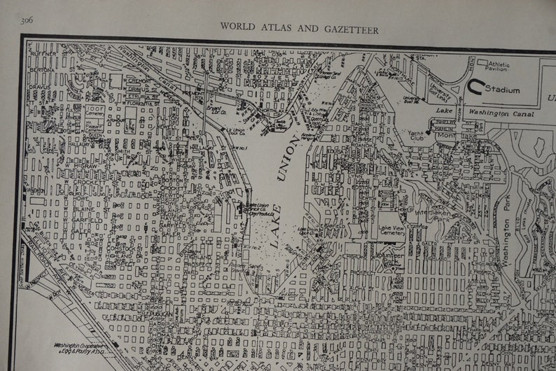 May include: A black and white map of a city with a lake labeled "Lake Union" and a stadium labeled "Stadium". The map also includes a canal labeled "Washington Canal" and a park labeled "Washington Park".