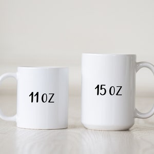 May include: Two white ceramic mugs with black text. The smaller mug is 11 oz and the larger mug is 15 oz.