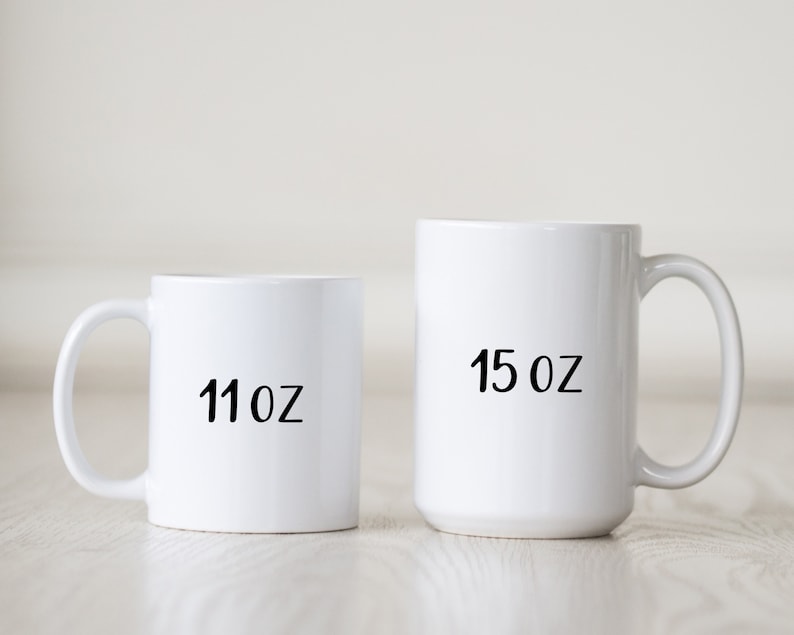 May include: Two white ceramic mugs with black text. The smaller mug is 11 oz and the larger mug is 15 oz.