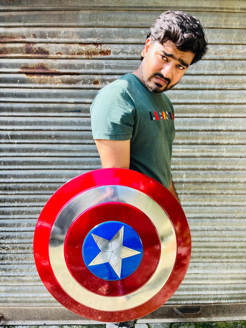 Pu&ograve; includere: Uno scudo di Captain America rosso, bianco e argento, con un centro blu e una stella argentata. Lo scudo ha un design circolare con anelli concentrici colorati. &Egrave; un oggetto di scena o da collezione.