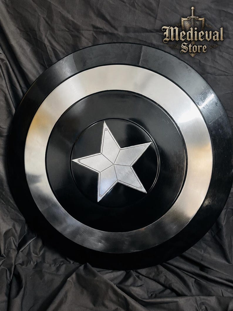 May include: A black and silver shield with a central silver star design. The shield has a circular shape with concentric rings of black and silver. The text "Medieval Store" is visible in the upper right corner.