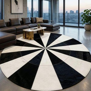 Peut inclure: Un grand tapis circulaire présentant un motif géométrique à fort contraste composé de segments triangulaires alternés noirs et blancs rayonnant depuis le centre, créant un design en étoile audacieux sur toute la surface du tapis.