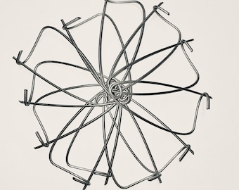 May include: A grayscale image of a wire sculpture. The sculpture is a complex arrangement of curved and straight metal wires, forming a circular, flower-like shape. The wires intersect and loop, creating a three-dimensional effect against a white background.