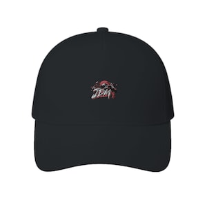 Può includere: Un cappellino da baseball nero con un design grafico centrale. Il design include il testo bianco JDM, un motivo solare circolare rosso e una piccola sagoma nera di un'auto, il tutto su uno sfondo scuro sulla parte anteriore del cappellino.