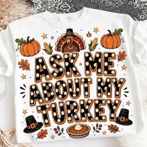 Może przedstawiać: Biała bluza z okrągłym dekoltem z nadrukiem graficznym z napisem ASK ME ABOUT MY TURKEY czarnymi literami w białe kropki. Wzór zawiera indyka w kapeluszu, pomarańczowe dynie, kukurydzę, ciasto i jesienne liście.