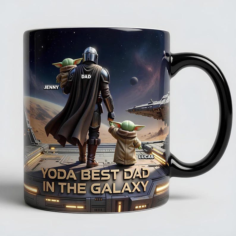 以下が含まれることがあります： 黒いコーヒーマグ。スターウォーズのデザインで、「YODA BEST DAD IN THE GALAXY」の文字が入っています。マンダロリアンとグローグーが描かれており、「Jenny」と「Lucas」の名前がマグに書かれています。