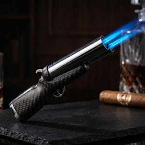 Op de afbeelding: Een dubbelloops aansteker met een handgreep met koolstofvezeltextuur en een gepolijste metalen afwerking. De aansteker stoot twee helderblauwe vlammen uit de lopen en is voorzien van een trekker en een strak, modern ontwerp voor gebruik.
