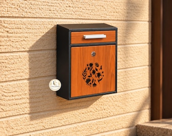 Puede incluir: Un buzón rectangular de pared con marco negro y panel frontal de madera. La parte delantera incluye un tirador plateado, una cerradura circular y un diseño floral negro recortado. Un pequeño logotipo circular muestra el texto LuckyCraftHub.