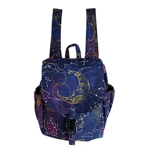 May include: A small backpack with a celestial design. The bag features a navy blue background with a gold crescent moon and constellation pattern. It has adjustable straps, a top handle, and a black buckle closure. The side pockets and flap also display the celestial print.