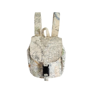 May include: A miniature backpack with a map pattern. It has a flap closure secured by a black buckle, adjustable straps, and a top handle. The map design incorporates beige, blue, and black hues.