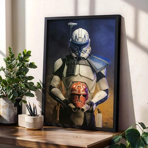 Pode incluir: Uma impressão de arte de parede vertical emoldurada apresentando um soldado clone com armadura branca e azul segurando um capacete laranja e branco. O soldado usa um capacete com uma barbatana azul contra um fundo azul escuro e laranja.