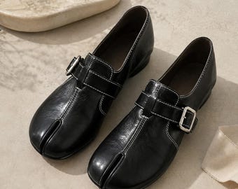 Sapatos Tabi femininos de couro preto, sapatilhas vintage com fivela e bico dividido, mocassins de couro legítimo com salto baixo, sapatilhas retrô confortáveis de tamanho largo.