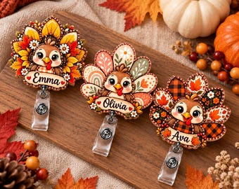 May include: Three turkey-themed badge reels featuring cartoon turkeys with colorful tail feathers. Each badge reel has a name tag at the bottom labeled Emma, Olivia, or Ava. The designs include autumn-inspired patterns like sunflowers, plaid, and leaves, with clear plastic clips attached to the base of each piece.