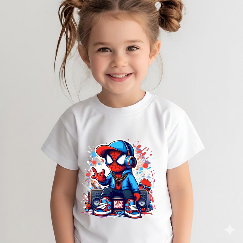 May include: A white t-shirt featuring a graphic print of a stylized character wearing a blue hoodie, a red and blue baseball cap, headphones, and a gold chain. The character sits on a boombox with a skateboard nearby, surrounded by paint splatters.