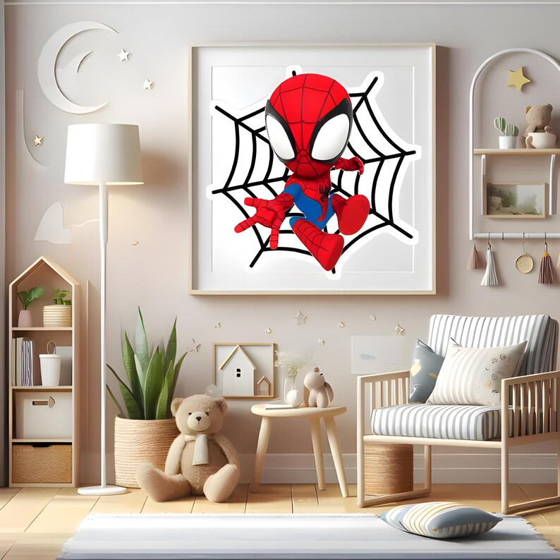 May include: A square framed wall art piece featuring a stylized red and blue superhero character with large white eyes, positioned in the center of a black spiderweb design against a white background, displayed in a light-colored wooden frame.
