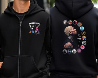 May include: Black zip-up hoodie with the text "Breezy Bowl" and a colorful graphic on the front. The back features a portrait of a person with a circle of images and a signature.
