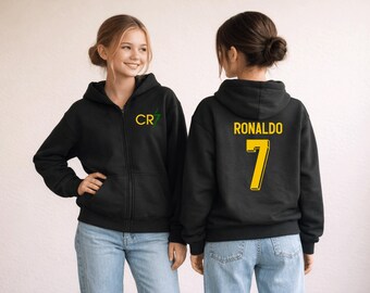 May include: Two people wearing black zip-up hoodies. The front of one hoodie has a green and yellow "CR7" logo. The back of the other hoodie displays "RONALDO" and the number "7" in yellow.