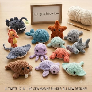 May include: A collection of twelve crocheted marine animals including a dark gray anglerfish, orange seahorse, blue whale, orange starfish, gray seal, light blue sea creature, gray stingray, purple octopus, orange crab, gray hammerhead shark, brown walrus, and a purple turtle, with a sign reading KSDigitalEmporium.
