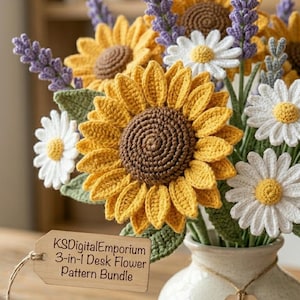 May include: A bouquet of crocheted flowers in a white vase, featuring yellow sunflowers with brown centers, white daisies with yellow centers, and purple lavender sprigs. A tan tag attached to the vase reads KSDigitalEmporium 3-in-1 Desk Flower Pattern Bundle.