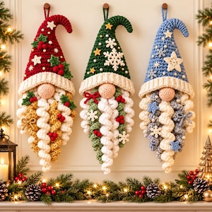May include: Three crocheted gnome wall hangings with pointed hats in red, green, and blue. Each gnome features a round nose, a long curly beard, and decorative accents like stars, snowflakes, holly leaves, and berries attached to the hats and beards.