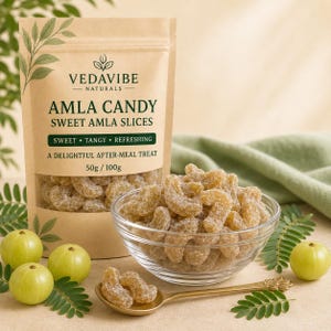 以下が含まれることがあります： VEDAVIBE NATURALS AMLA CANDY SWEET AMLA SLICESと書かれたベージュの袋には、乾燥した果実が見える透明な窓があります。ガラスのボウルには砂糖をまぶした黄金色の乾燥アムラが入っており、金のスプーンと新鮮なアムラの実が添えられています。