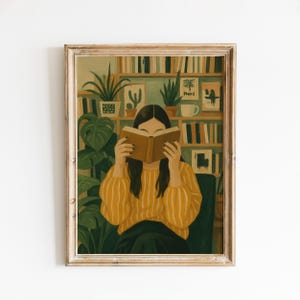 May include: A framed art print depicting a person with dark hair wearing a mustard yellow striped sweater, holding an open book in front of their face. The background features a wooden bookshelf filled with books, potted plants, and framed wall art.